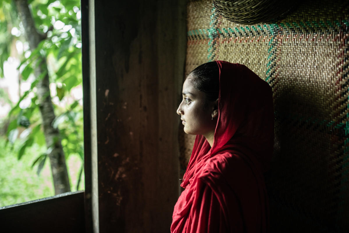 Pige i Bangladesh, der kigger ud af vinduet