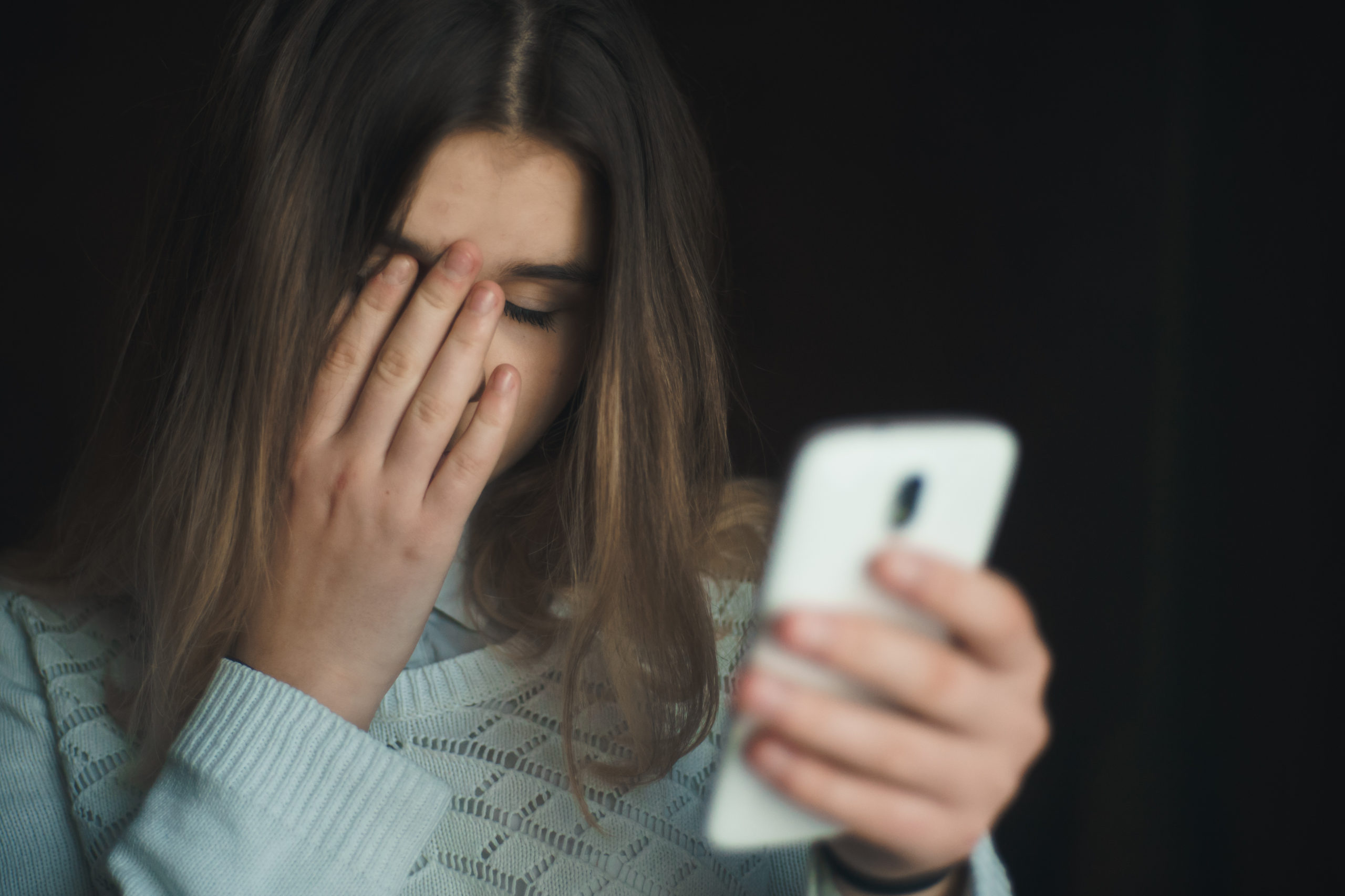 Billede af barn med telefon, der bliver mobbet på nettet