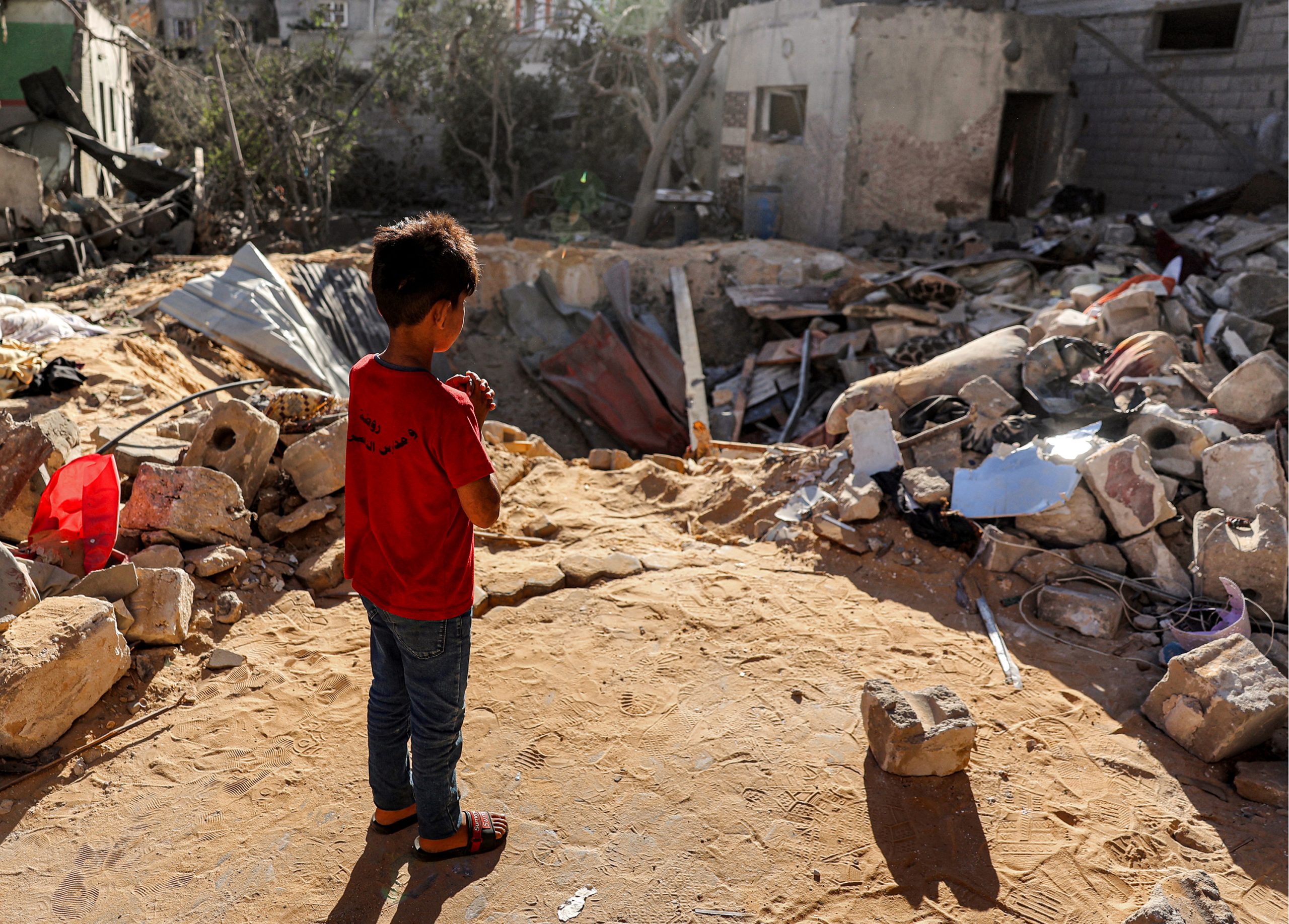 CH11408339_BOUGHT-AGENCY-IMAGE-SEE-USAGE-RIGHTS-A-boy-stands-before-an-impact-crater-at-the-site-of-a-building-that-was-hit-by-Israeli-bombardment-in-Rafah-Gaza
